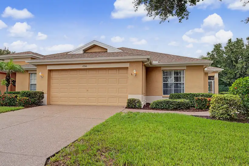 2241 Worthington Greens Dr — front of the villa with two-car garage